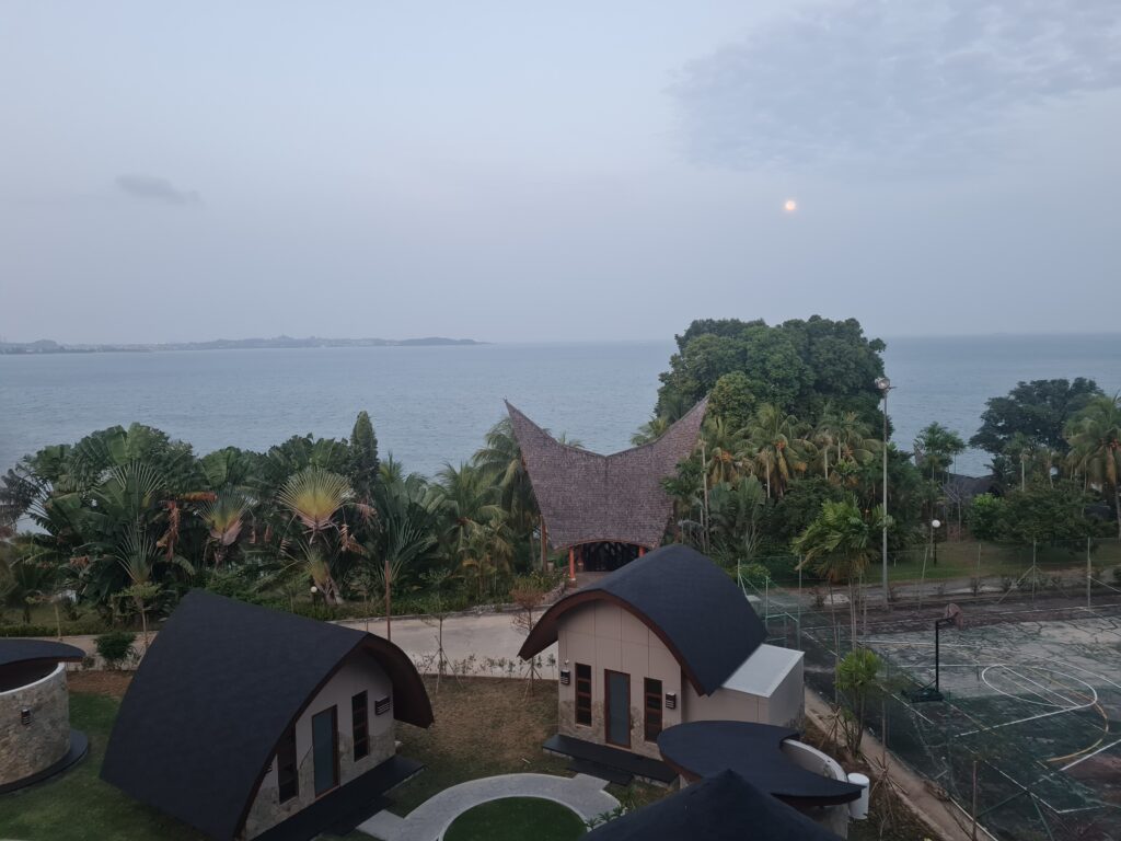 Early morning view of Batam View Beach Resort villas with the moon still visible in the sky.
