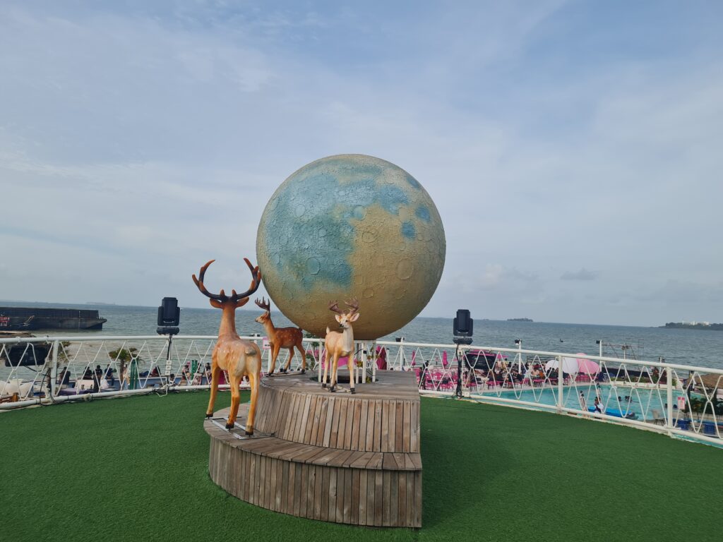 Large crescent moon sculpture and deer statues at Bluefire Beach Club Batam.