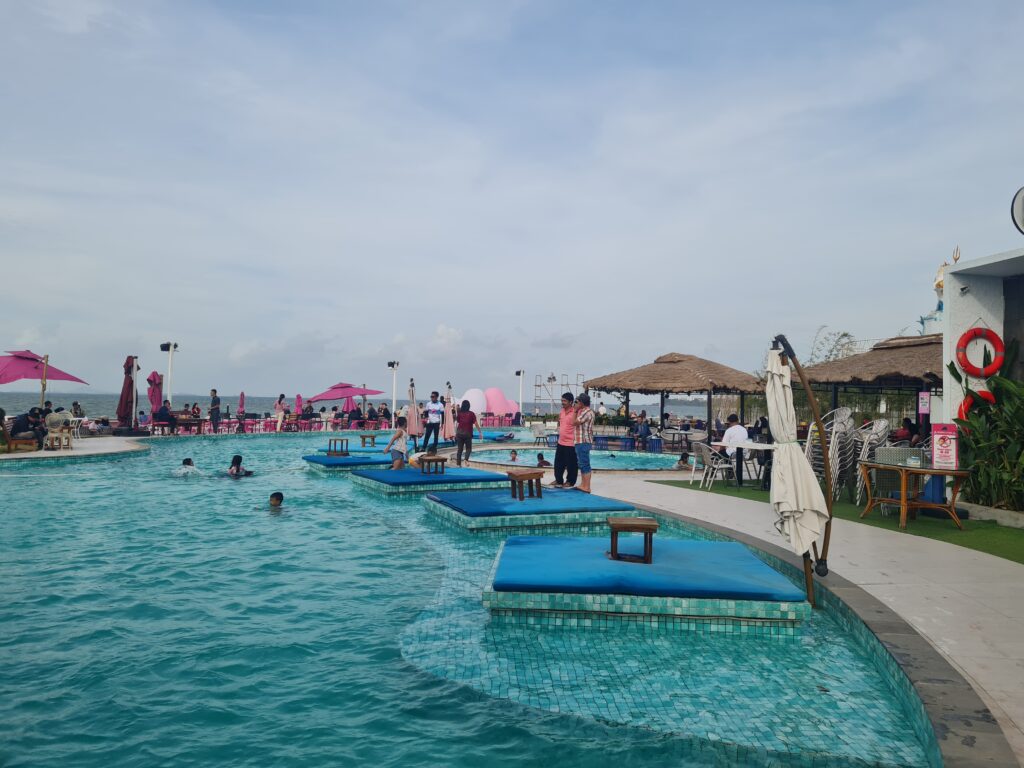 Vibrant swimming pool area with pink umbrellas and ocean view at Bluefire Beach Club.
