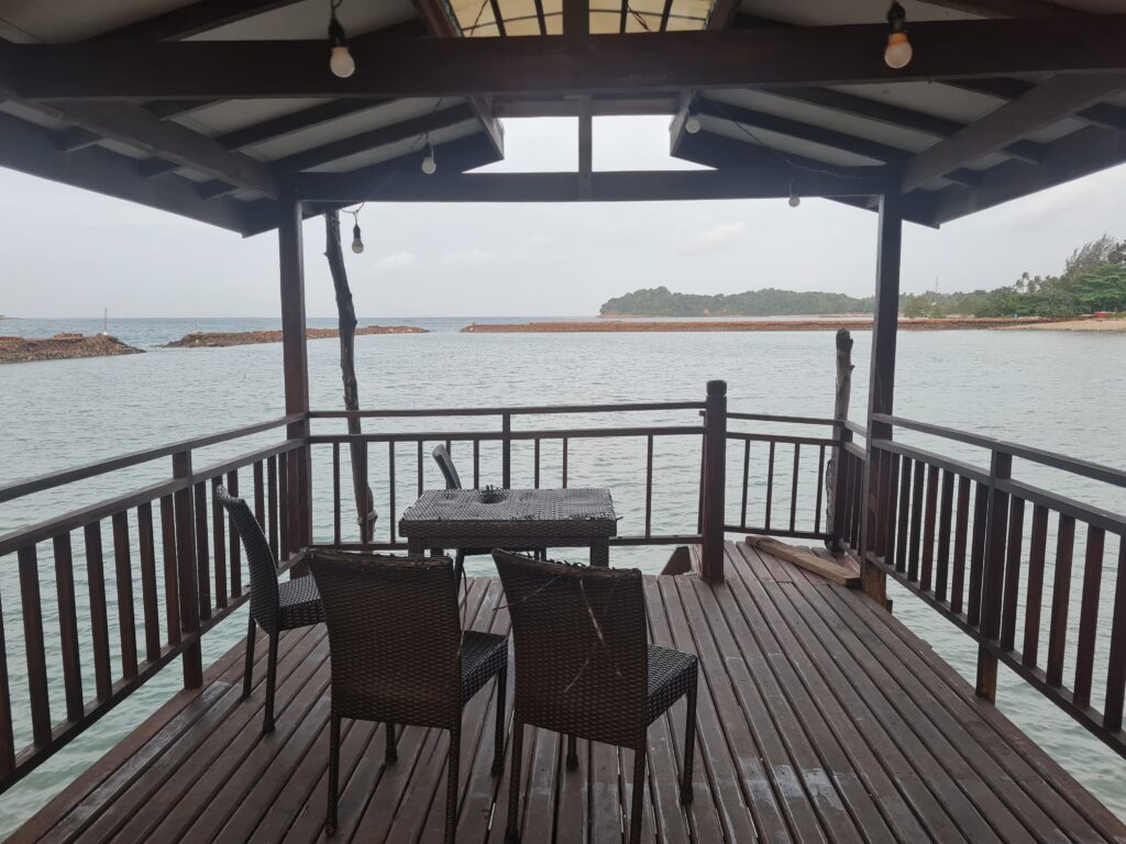 Scenic wooden gazebo with rattan furniture overlooking the ocean at Batam View Beach Resort.