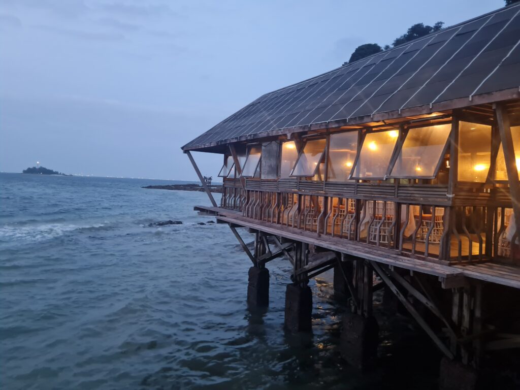 View of the calm sea and distant islands from the overwater deck of Kelong Seafood Sunset Bistro.