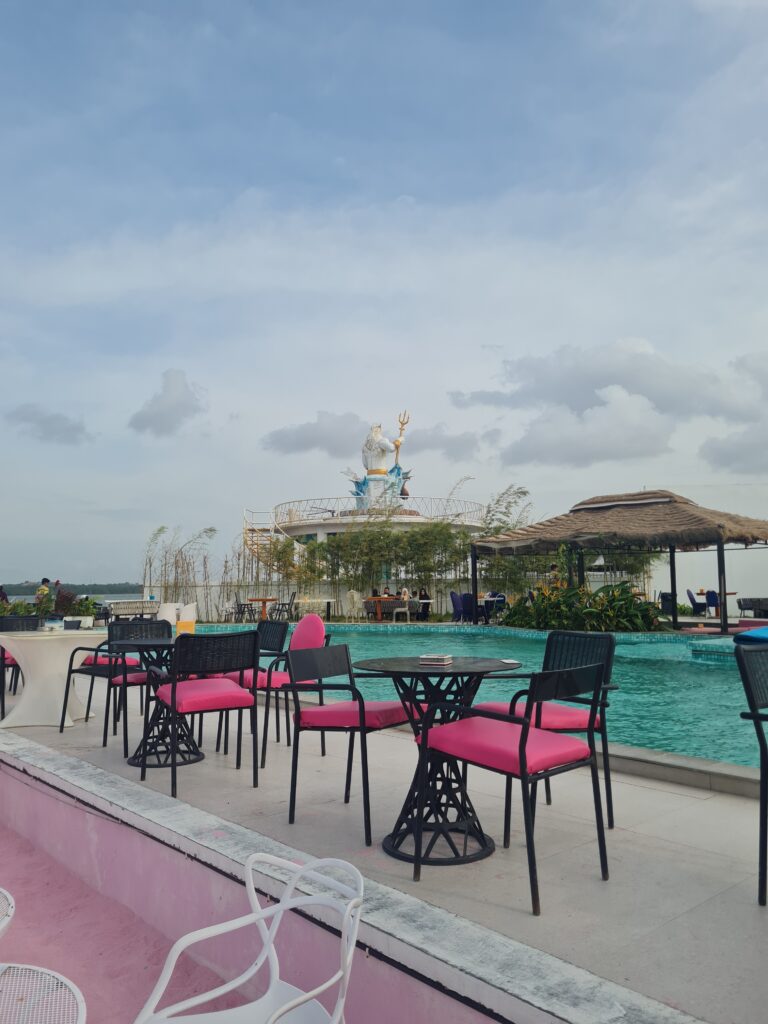 The central swimming pool at Bluefire Beach Club featuring a Poseidon statue