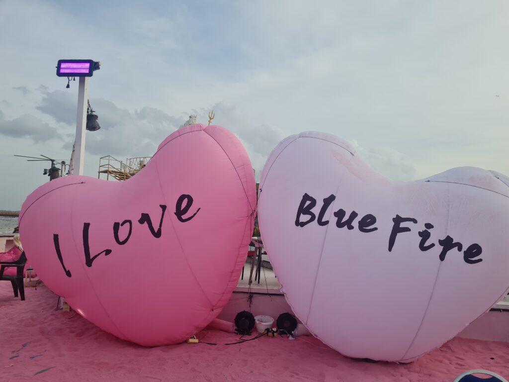 "I Love Blue Fire" inflatable landmark on the pink sand, popular for Instagram photos.