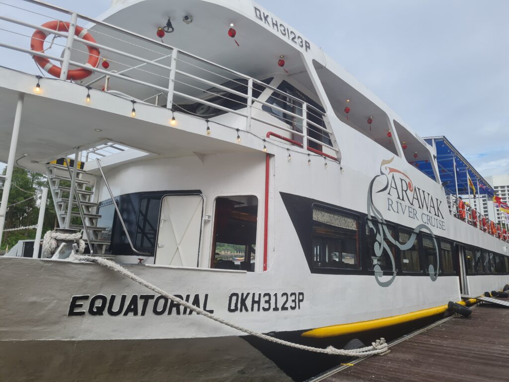 The Equatorial Sarawak River Cruise boat docked at the Kuching waterfront for a sunset tour.