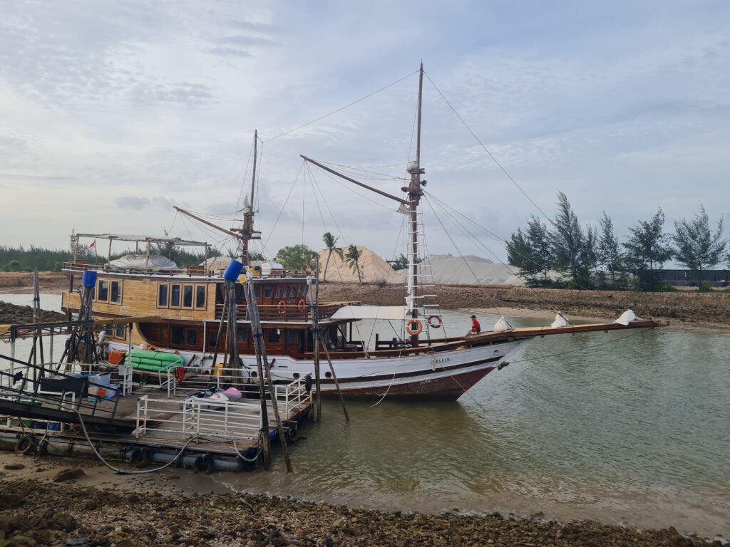 Decorative traditional boat feature docked near the Bluefire Beach Club waterfront.