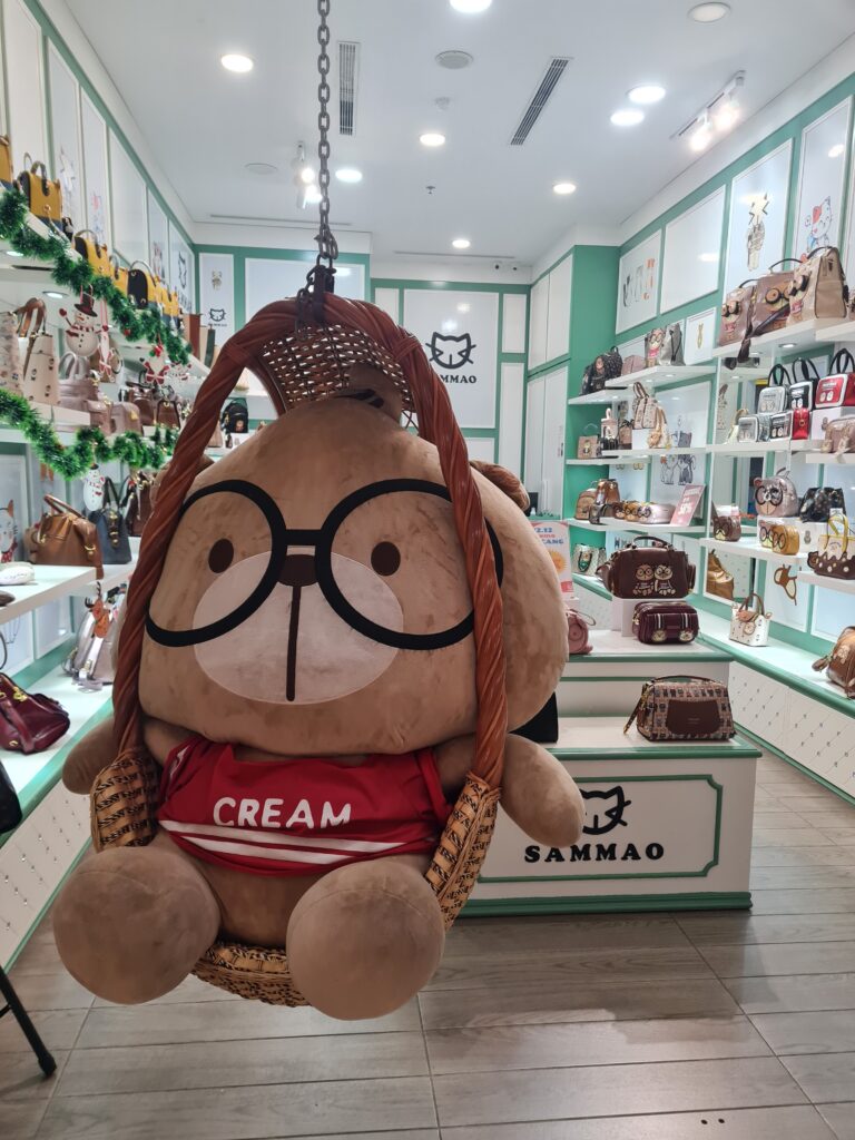 A view of one of the retail stores inside Grand Batam Shopping Mall where a big teddy bear sitting on a swing at the entrance.